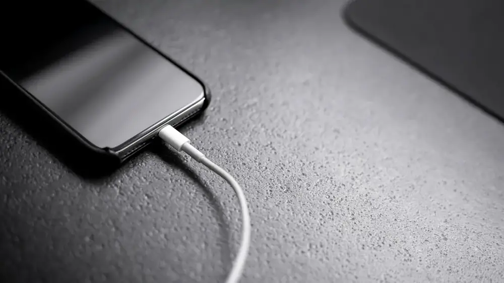 Şarj kablosu takılı siyah bir akıllı telefon