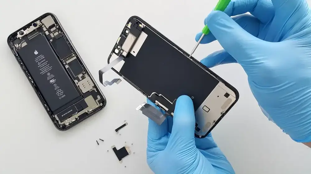 Gloved technician replacing a phone battery